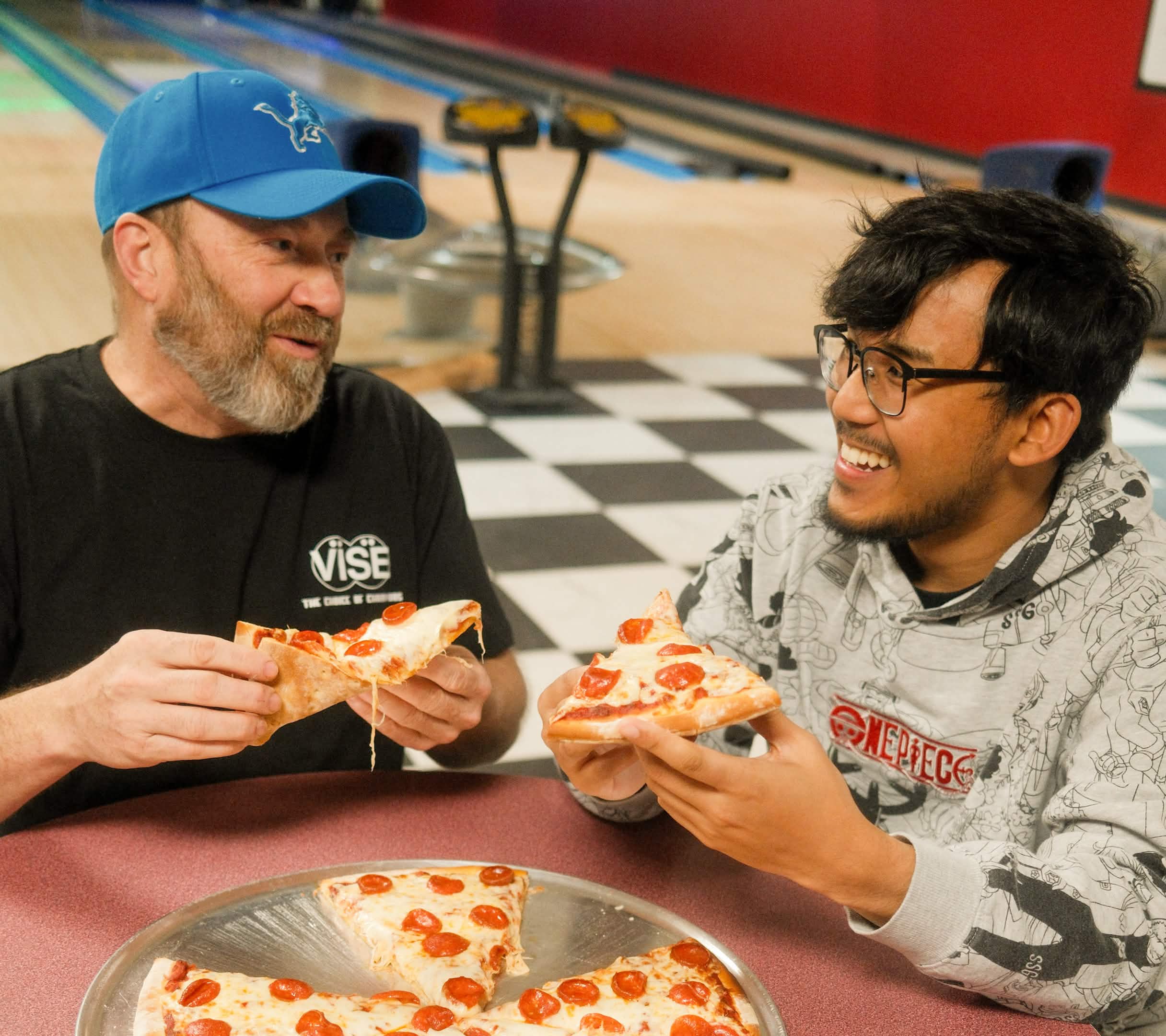 Bowlers sharing pizza at Century Lanes